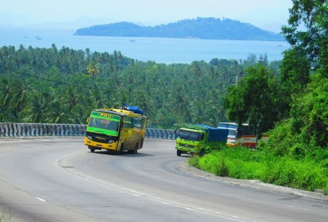 Bus Family Raya dan Lampung Jaya berusaha menyalip truk Fuso di tanjakan Tarahan, Lampung. Di kejauhan nampak panorama Selat Sunda (foto oleh Subastian Yusuf Panggabean)